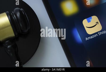 A close up of an iPad screen displaying the amazon shopping app alongside a judge's gavel Stock Photo