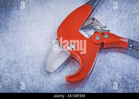 Pipe cutter on scratched metallic background top view construction concept Stock Photo