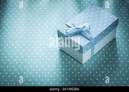 Present box on blue polka-dot background holidays concept Stock Photo