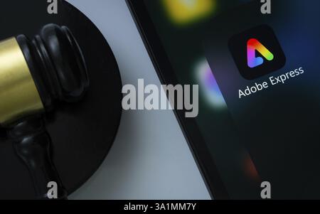 A close up of an iPad screen displaying the Adobe Express app alongside a judge's gavel Stock Photo