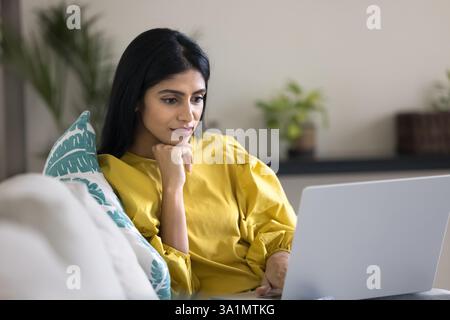 Indian woman watching educational or informative content on laptop Stock Photo