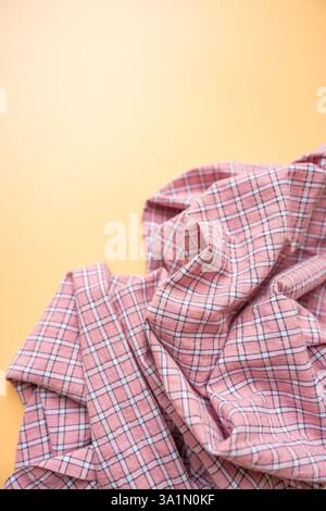 Pink plaid fabric with soft folds on beige background, textile material close-up, copy space Stock Photo