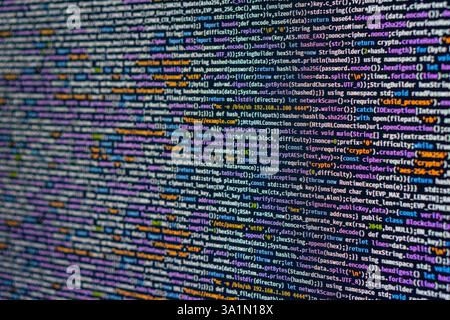 Image of a code editor displaying blurry lines of computer programming code, highlighting syntax elements like keywords, strings, numbers, and functio Stock Photo