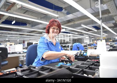 friendly woman working in a microelectronics manufacturing factory - component assembly and soldering Stock Photo