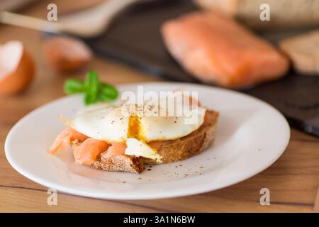 A slice of bread with lightly salted red fish and a cooked egg for breakfast. Stock Photo