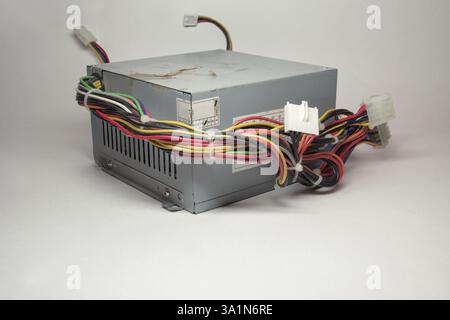 computer ATX power supply unit front side with ventilation holes. colorful power cords for conneting to drives are directly from non-modular case Stock Photo