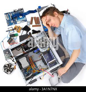 Frustration while trying to assemble computer hardware. Man has problems with technology and electronics Stock Photo