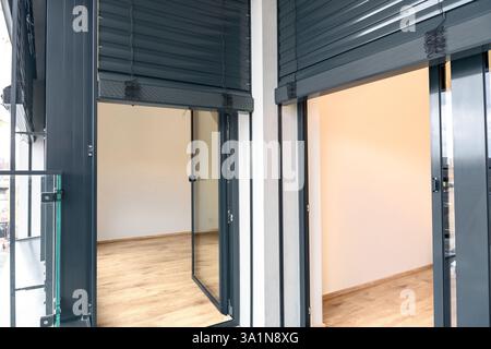 Modern tilt and turn balcony doors with closed roller shutters in contemporary apartment Stock Photo