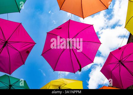 Multicolored umbrellas against a blue sky Stock Photo