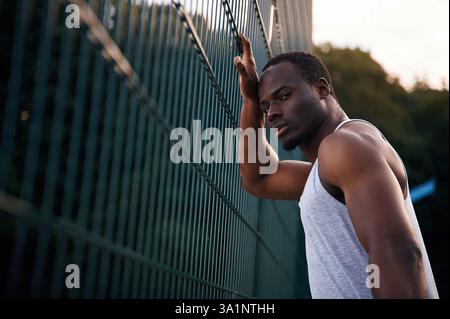 Posing and standing. Handsome black man is posing outdoors at daytime. Stock Photo