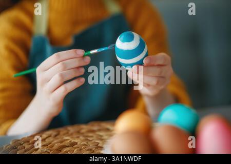 Woman is painting eggs. Happy family preparing for Easter. Stock Photo