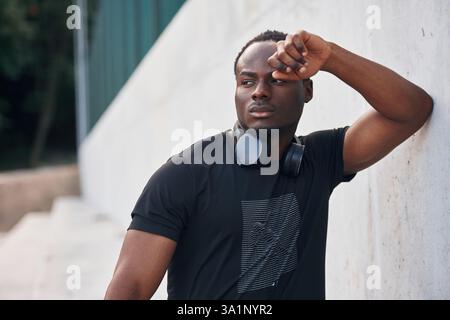 Posing and standing. Handsome black man is outdoors at daytime. Stock Photo