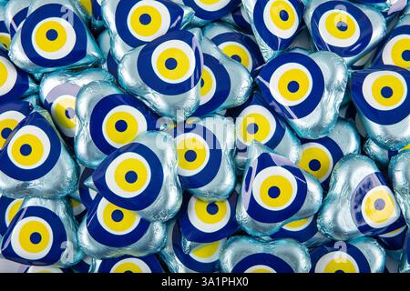 Chocolate with heart shaped evil eye beads covered with aluminum foil. Heart shaped chocolates wrapped in aluminum foil to be given as gifts on Valent Stock Photo