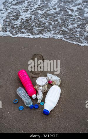 A beach littered with plastic bottles and other trash. Scene is one of sadness and concern for the environment Stock Photo