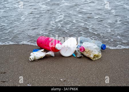 A beach littered with plastic bottles and bags. Scene is one of sadness and concern for the environment Stock Photo