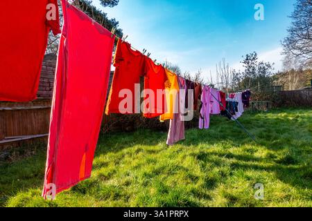 Clothes hanging to dry on a washing line in a back garden in early March Stock Photo