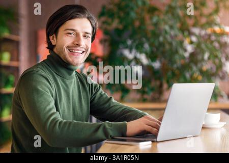 Cheerful programmer working at cafe, enjoying his job Stock Photo