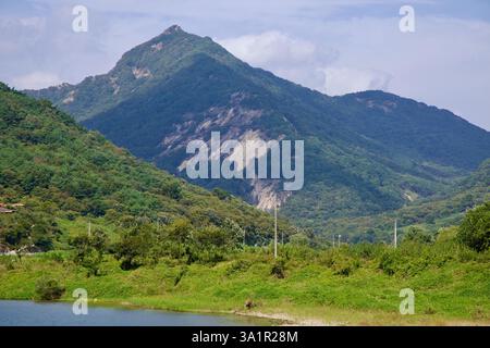 Sunchang County, South Korea - October 4, 2021: A rugged mountain peak rises above the lush greenery along the Seomjin River, with patches of exposed Stock Photo