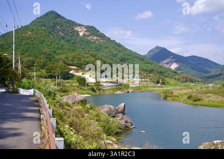 Sunchang County, South Korea - October 4, 2021: A scenic view of the Seomjin River flowing beneath the towering Muryang Mountain, with a winding cycli Stock Photo