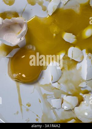 Messy cracked eggs on white background create abstract background plate. Stock Photo