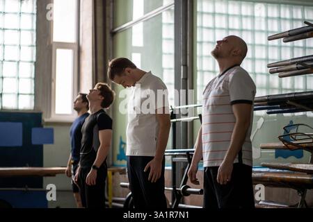 Athletic men warming up dynamic stretching, enhancing flexibility, waving arms before row training Stock Photo