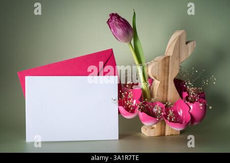 Self made vibrant white envelope sample egg shell with wooden bunny vase handmade decoration for Easter holiday. Copy space greeting card present gift ideas. Tulip flower Creative reuse zero waste sustainable living eco-friendly me made decor. Minimalistic idea repurposed materials green lifestyle Stock Photo