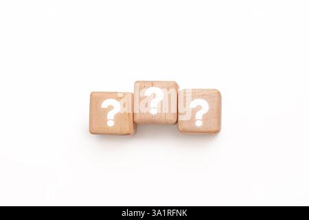 Three wooden blocks with white question marks in straight line against white background. Symbolizing for concepts like problem-solving, brainstorming, Stock Photo