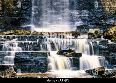 Waterfall with flowing water on the rocks in long exposure Stock Photo