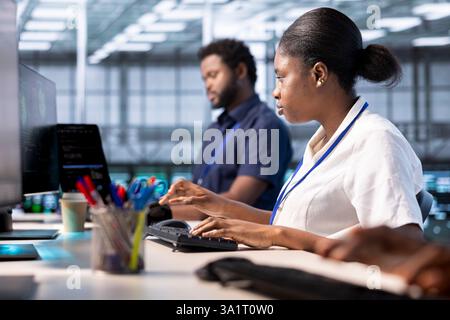 Woman in data center workspace running system diagnostic tests on PC to fix problems. African american employee deploying and error checking utilities on computer to fix network issues performance Stock Photo