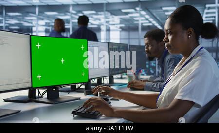 Software developer in server farm ensuring data remains shielded from potential threats using mockup PC. IT expert safeguarding data center against hackers with green screen computer, camera A Stock Photo