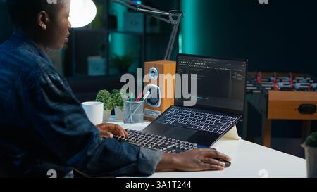 Freelancing admin in home office using laptop to write programming language code. Software technician working from home using notebook device to build application, camera A Stock Photo