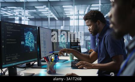 Engineer in data center implementing advanced AI driven predictive maintenance systems to proactively identify and resolve potential hardware failures before they impact operations, camera A Stock Photo