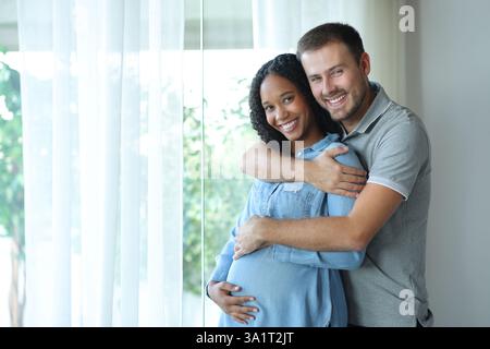 Black pregnant woman and her husband looking at camera at home Stock Photo