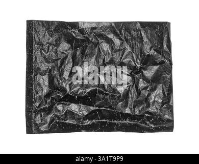 Crumpled black thin glossy grunge paper sheet texture on white background. Stock Photo