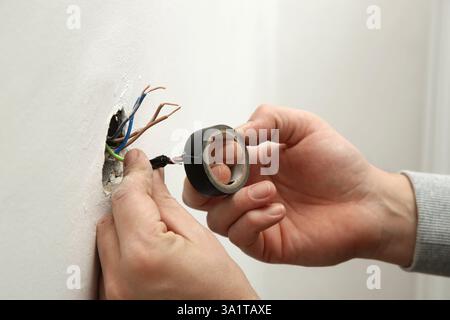 Electrical Outlet Repairing and Assembling - home improvement concepts. Master electrician installs a socket in the house. DIY home project. Stock Photo