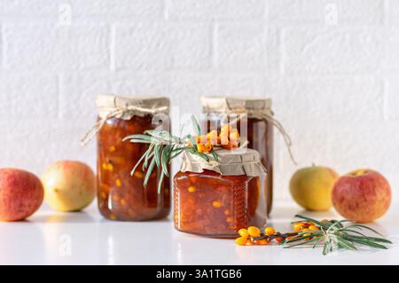 A collection of jars filled with golden seabuckthorn and apple jam. Copy space. Stock Photo