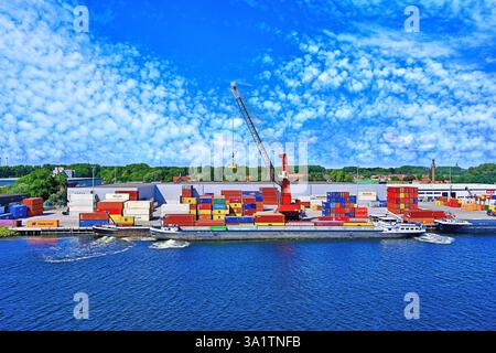 Small container ship carries loading in the North Sea Canal  Netherlands Amsterdam against deep blue sky and mackerel cloud Stock Photo