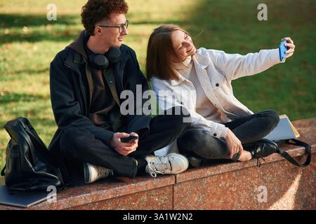 Taking a selfie. Two young students are together outdoors. Stock Photo
