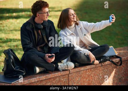 Taking a selfie. Two young students are together outdoors. Stock Photo