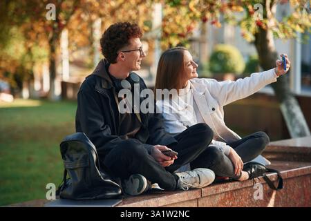 Taking a selfie. Two young students are together outdoors. Stock Photo