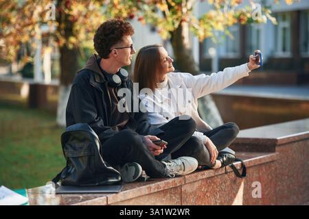 Taking a selfie. Two young students are together outdoors. Stock Photo