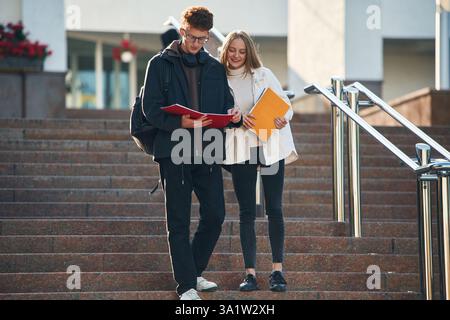Front view, walking the stairs. Two young students are together outdoors. Stock Photo