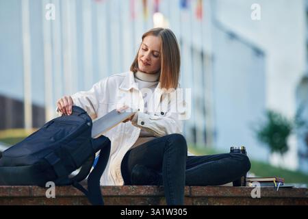 Young female student in casual clothes is outdoors. Stock Photo