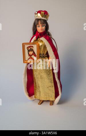 1970s Action Girl doll by Palitoy in beauty queen outfit (gold dress, fur-trimmed red cape, crown and framed photograph) Stock Photo