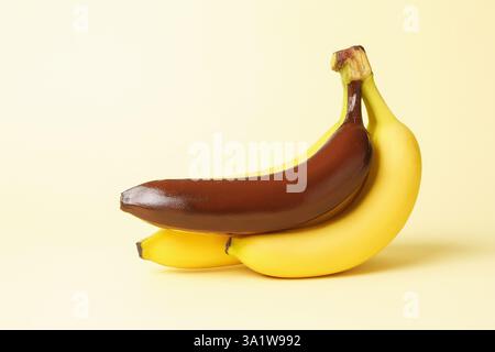 Stop racism. Bunch of yellow bananas with dark one on beige background Stock Photo