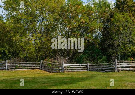 Rustic Split-rail fence separating forest from parkland Stock Photo