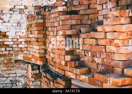 Stack of old work bricks on construction site, selective focus Stock Photo