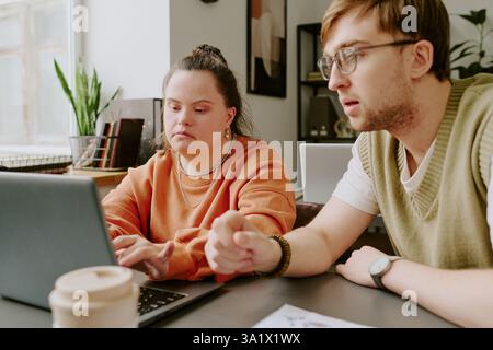 Medium close up of two Caucasian colleagues focused on developing new app for computers while working in office Stock Photo