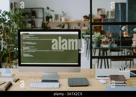Medium close up of huge monitor with code lines and office supply on desk Stock Photo