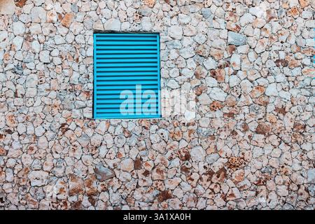 Stone Wall Texture Background With Antique Blue Shutters Window Stock Photo